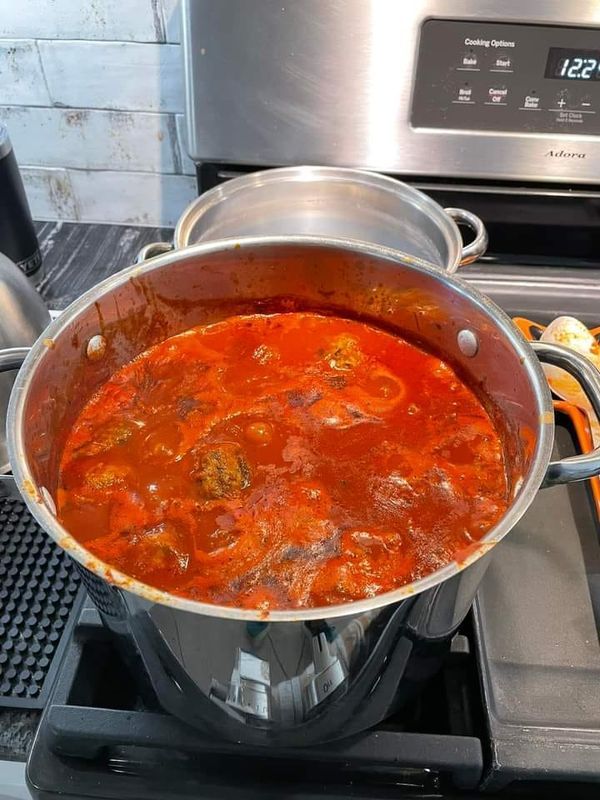 a pot full of soup sitting on top of a stove