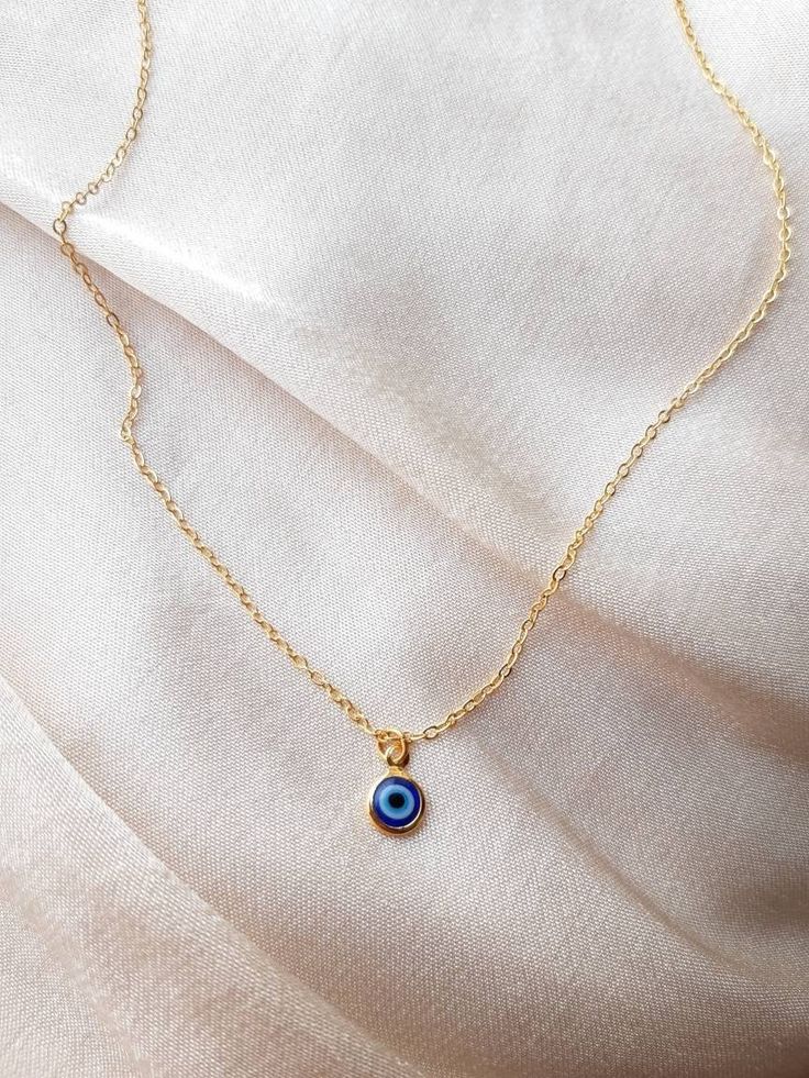 24K gold plated handmade necklace with a small blue evil eye pendant (For the baby blue evil eye necklace in the picture, check out this listing: https://www.etsy.com/uk/listing/1043552572/24k-gold-plated-small-baby-blue-evil-eye?ref=shop_home_active_2&frs=1) Chain length:17 inches (~42.5cm) Chain length may be shortened FREE of charge, please add the length you would like in the personalisation box below upon ordering or message me! Everything comes beautifully wrapped, with a small jewellery p Adjustable Blue Necklace For Her, Adjustable Blue Necklace As A Gift For Her, Blue Dainty Necklace With Clavicle Chain, Dainty Blue Clavicle Chain Necklace, Dainty Blue Necklace With Delicate Chain, Everyday Handmade Blue Charm Necklaces, Blue Spiritual Gold-plated Necklaces, Dainty Blue Necklace For Her, Evil Eye Pendant Charm Necklace For Everyday