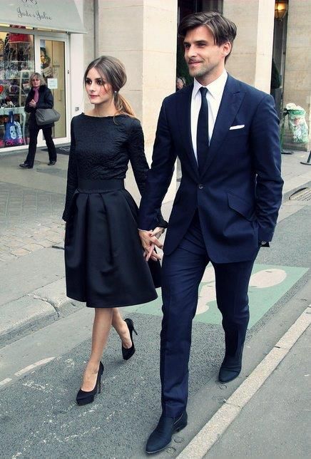 a man and woman walking down the street holding hands