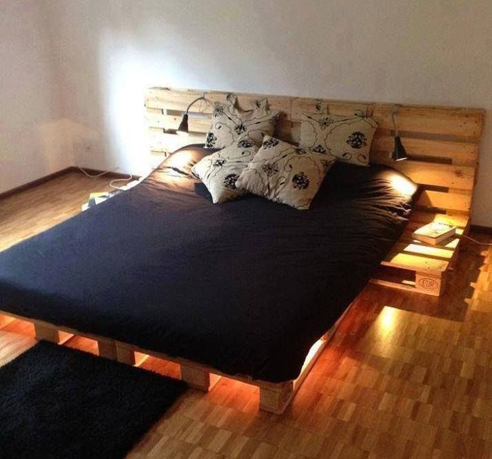 a bed made out of wooden pallets with lights on the headboard and foot board