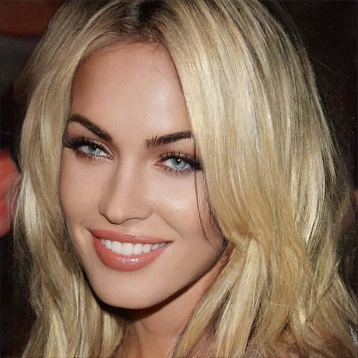 a close up of a woman with blonde hair and blue eyes smiling at the camera