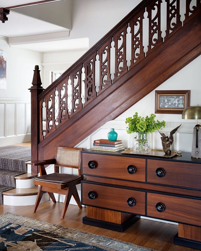 a wooden stair case next to a bed in a room with a rug on the floor