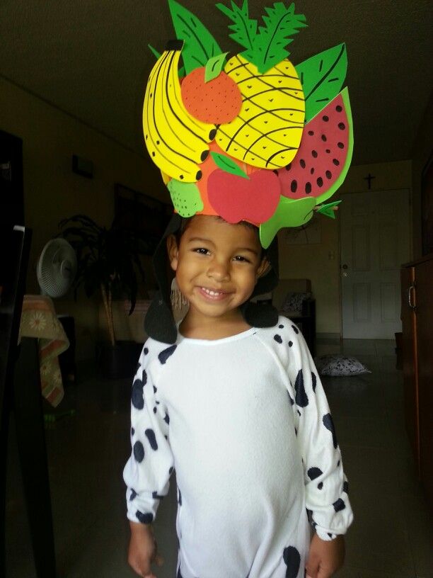 a young boy wearing a paper fruit hat