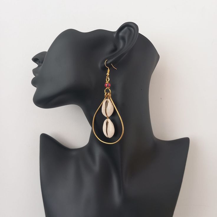 These stylish, handmade earrings combine a traditional cowrie shell with brass loop accents, creating a timeless beauty that is sure to turn heads. The careful crafting and quality materials make these earrings a unique, durable way to accessorize any look. Skillfully crafted in Kenya, these earrings are sure to make a statement. Earrings With Shells, Metal Hoop Earrings For Beach, Metal Drop Earrings For Beach, Adjustable Metal Earrings For Beach, Traditional Metal Jewelry For Beach, Bohemian Teardrop Earrings For Vacation, Bohemian Shell Earrings For Jewelry Making, Gold Beaded Earrings For Beach, Metal Beaded Earrings For Beach