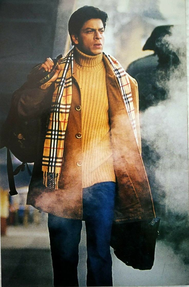 a man walking down the street wearing a coat and scarf