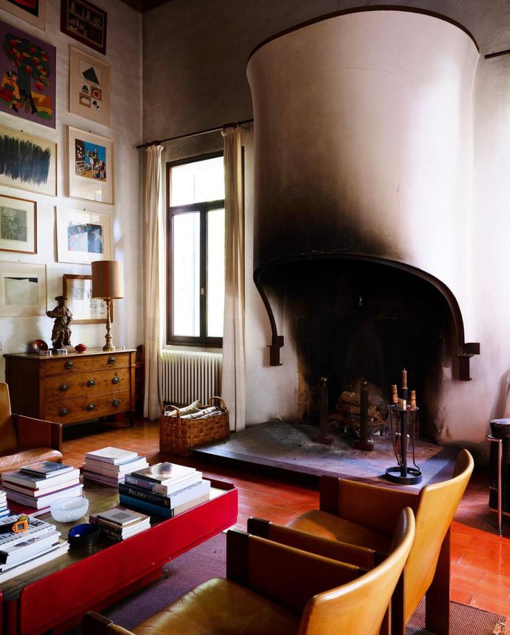 a living room filled with furniture and a fire place next to a wall covered in pictures