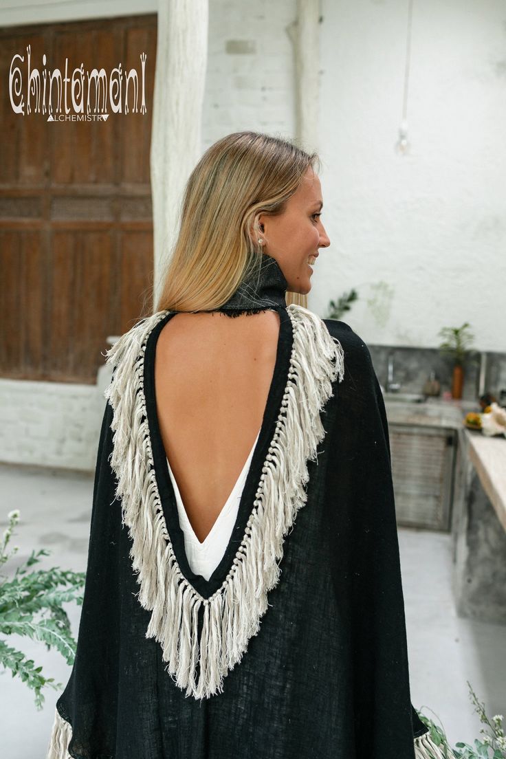 Cotton Open Back Poncho is a very original designer garment to compliment your boho outfit on a cool summer evening. High cotton canvas collar is reminiscent of elegant XIX century lady cloak, while long gorgeous linen fringe on the hemline brings an ultimate boho touch to the piece. The back of the poncho is open and also decorated with the statement fringes of our Alma Libra collection. It is made of 100% natural raw and very soft cotton. In hot climate you can wear this Poncho with our open b Bohemian Long Sleeve Cape One Size, Bohemian Long Sleeve Cape For Festivals, Bohemian Cape With Tassels For Fall, Bohemian Tassel Cape For Fall, Bohemian Poncho For Festivals, One Size Bohemian Cape For Festivals, Traditional Black Cape For Festival, Black Cape For Fall Festivals, Black Fall Festival Cape