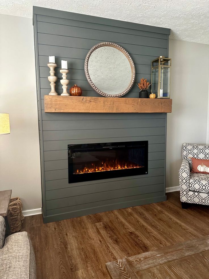 a living room with a fire place in the center and a mirror on the wall