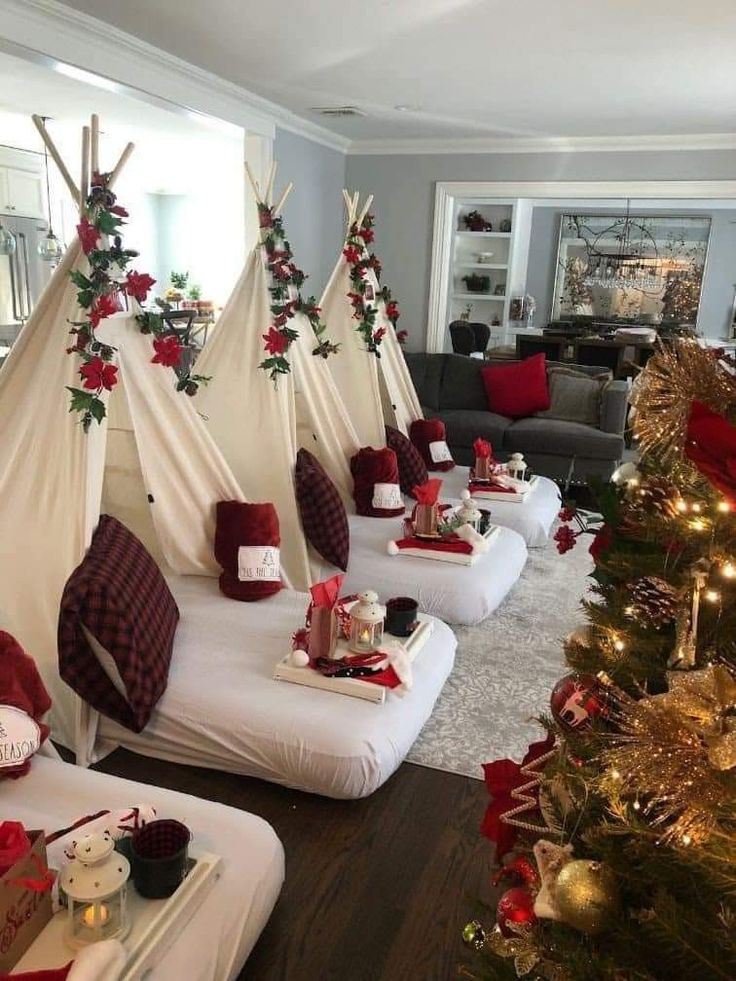 a living room filled with white couches covered in red and white blankets next to a christmas tree