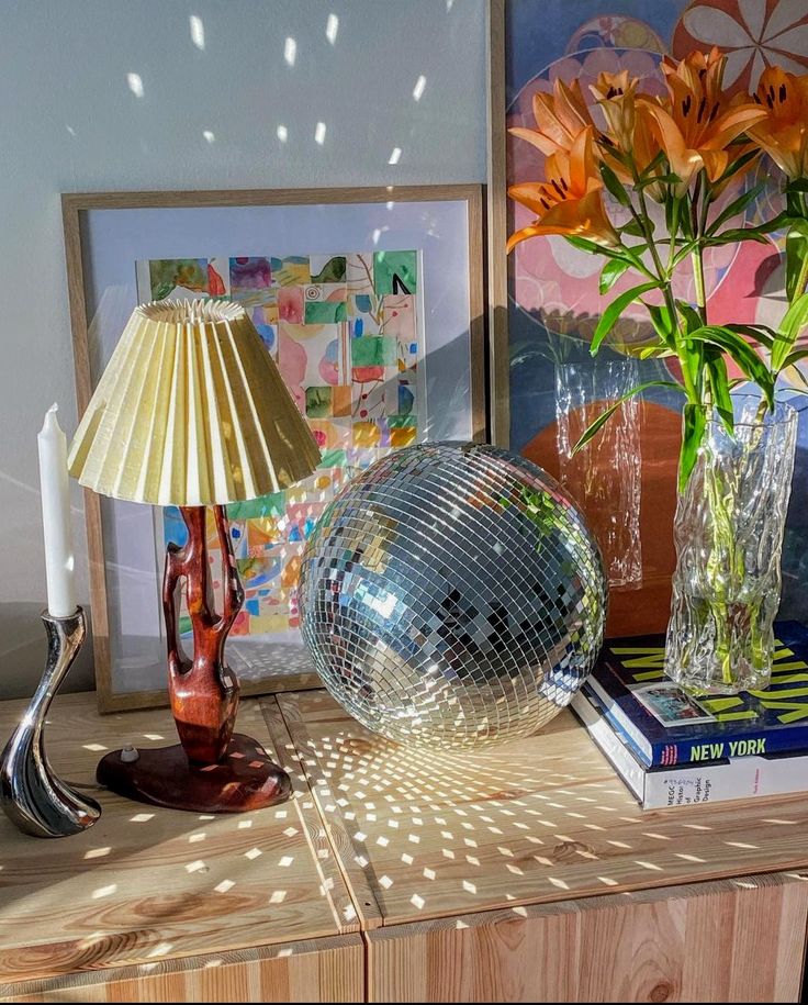 a disco ball lamp sitting on top of a table next to a vase filled with flowers