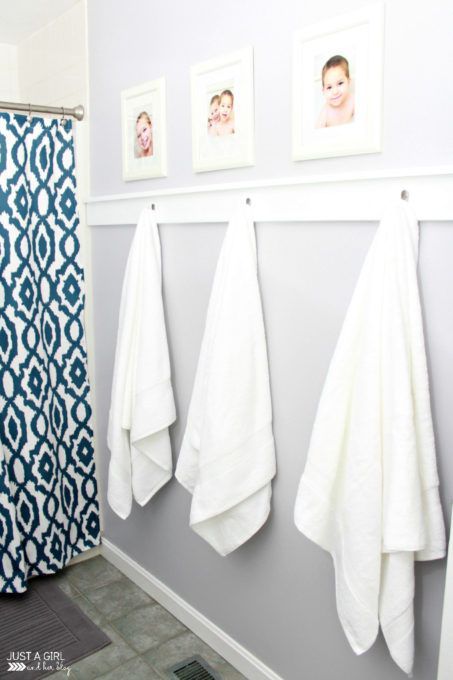 three towels hanging on the wall next to a blue and white shower curtain in a bathroom