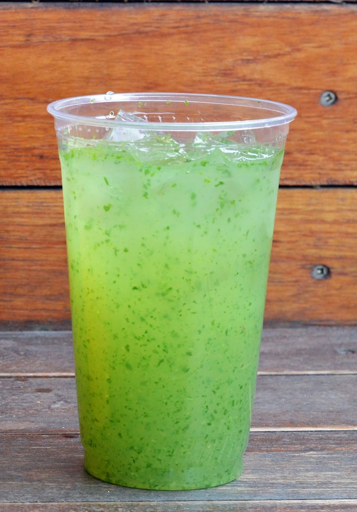 a green drink sitting on top of a wooden table