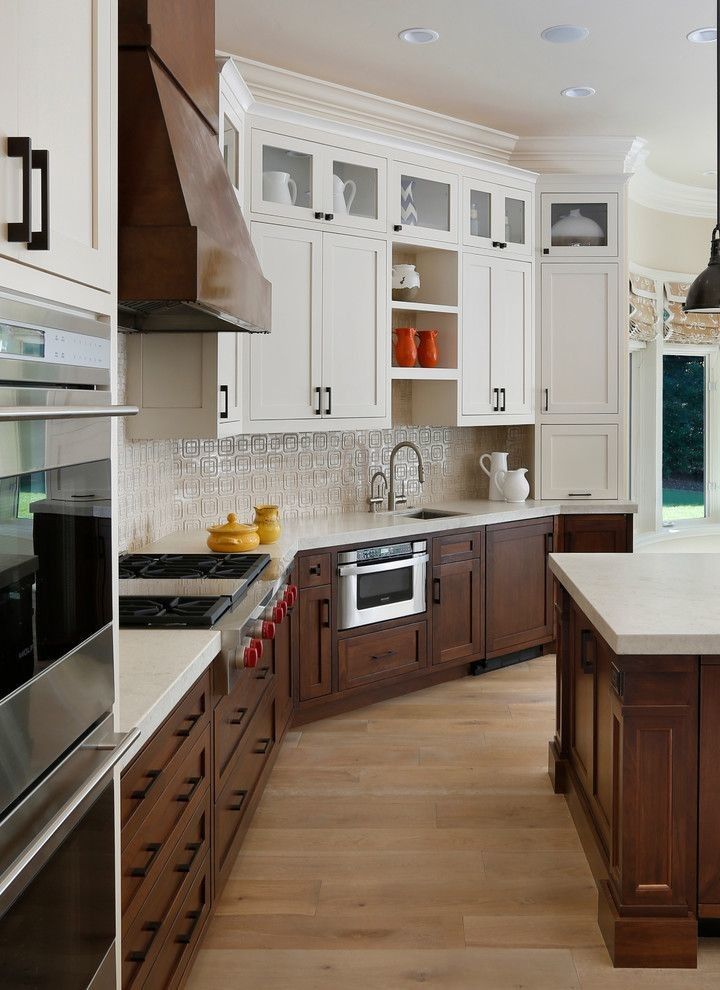 a large kitchen with white cabinets and wood flooring on the countertops, along with an island in the middle