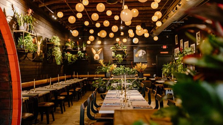 an empty restaurant with many tables and chairs set up for formal dinner or party guests