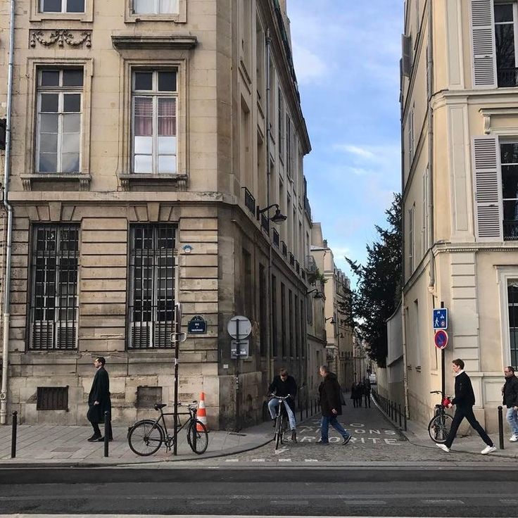 people walking down the street in front of some buildings