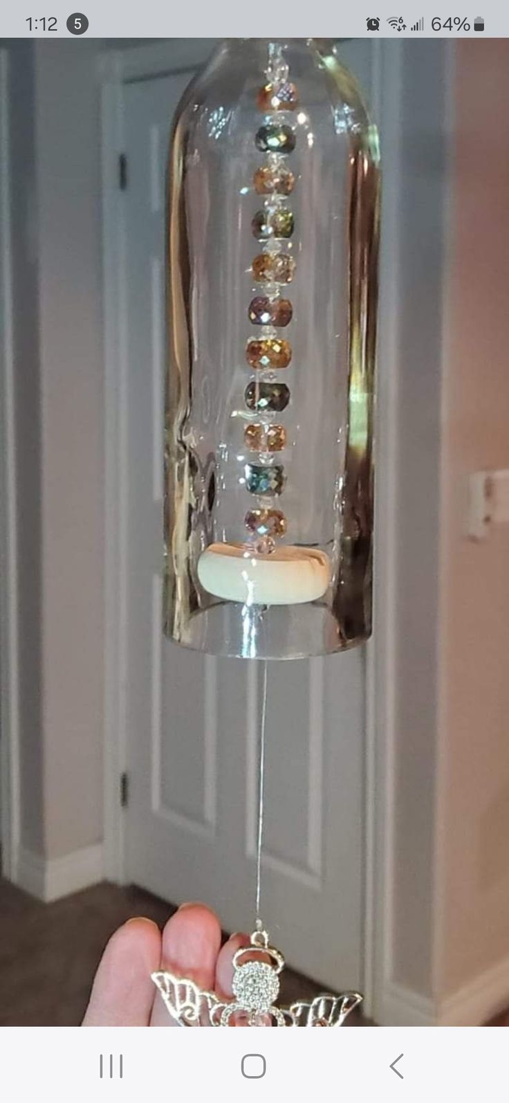 someone is holding a glass bird feeder with jewels on it