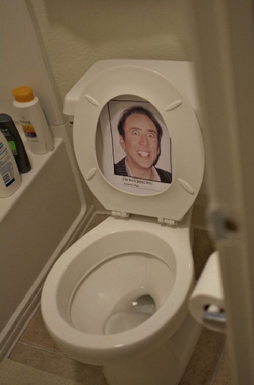 a toilet with the lid up and an image of a man's face on it