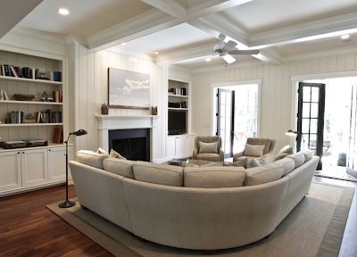 a living room filled with furniture and a fire place in the middle of a room