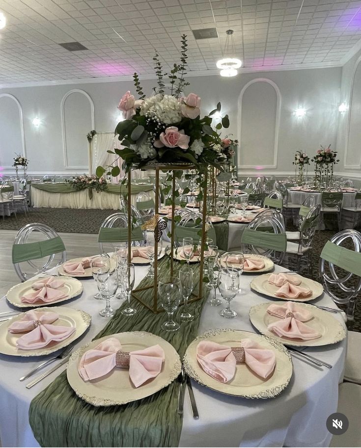 the table is set with pink napkins and place settings for an elegant dinner party