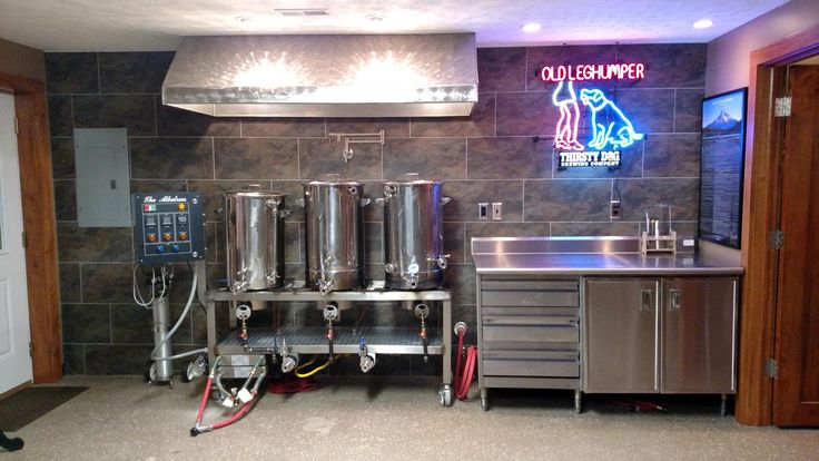 a kitchen area with stainless steel appliances and neon signs on the wall behind it,