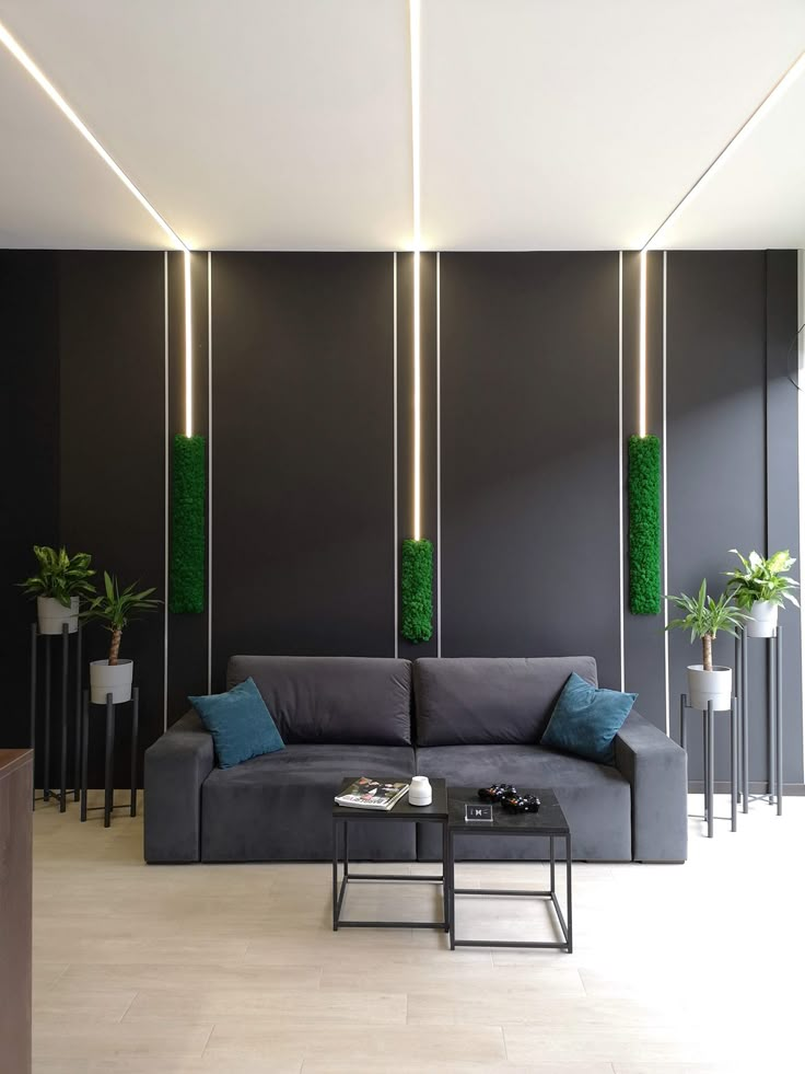 a modern living room with black walls and green plants in vases on the wall