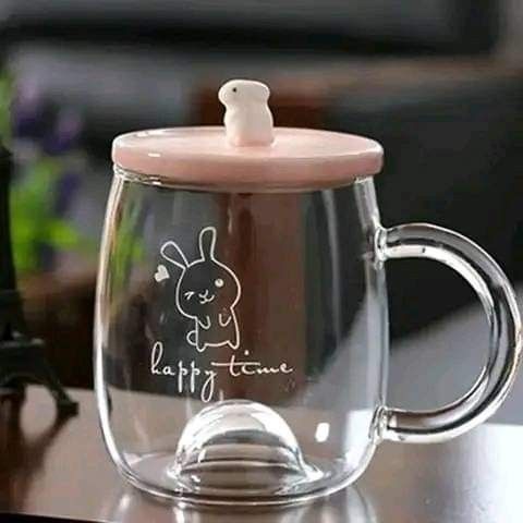 a glass cup with a bunny on it sitting next to the eiffel tower