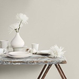 a table topped with white dishes and vases