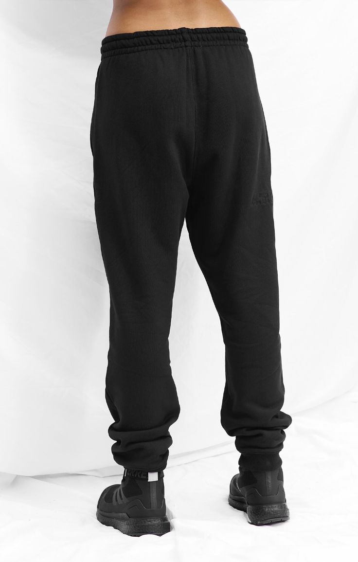 An elevated, unisex track pant made from A.T.G Sweat™ - our premium, heavy weight, 100% cotton French Terry. Featuring a limited edition embroidered logo, pair this essential with its matching crew/hoodie or layer with Sculpt™ & Vegan Puff™. 100% cotton Premium, heavy weight french terry Tonal limited edition logo embroidered on back of right leg A.T.G logo embossed metal tipped drawstring Soft inner elastic waistband for a secure yet relaxed fit Pockets in-built to side seam with colour matched Athleisure Tracksuit With Ribbed Waistband For Streetwear, Black Sweats With Comfort Waistband For Streetwear, Sporty Straight Leg Sweats For Streetwear, Streetwear Pants With Double-needle Straight Hem, Streetwear Techwear Sweatpants With Tapered Leg, Techwear Sweatpants With Tapered Leg For Streetwear, Techwear Tapered Leg Sweatpants For Streetwear, Cotton Sweatpants For Streetwear With Straight Hem, Straight Leg Sweats For Streetwear Athleisure