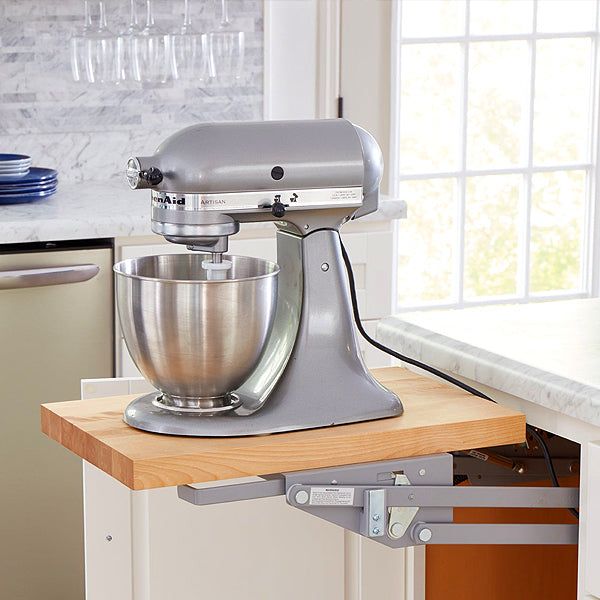 a silver mixer sitting on top of a wooden counter