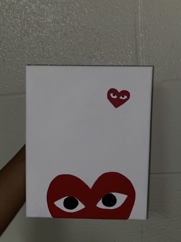 someone is holding up a card with an image of a heart and eyes on it