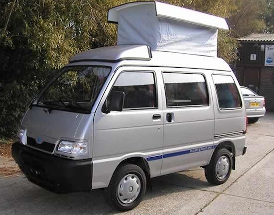 a silver van parked on the side of a road with a white roof top over it