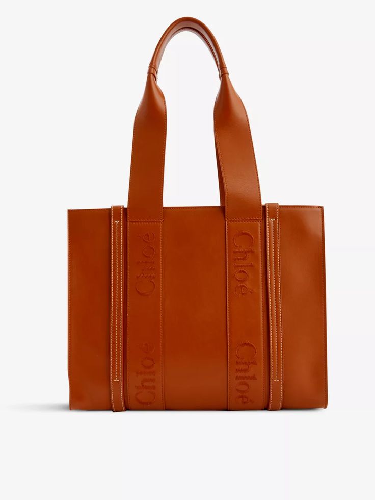 Conjuring up images of sun-dappled cobbles in Paris and boats bobbing along the coast of Monaco, Chloé’s latest Woody tote is made for French city breaks and beach holidays alike. Dreamt up in supple leather and shaped to a simple silhouette, it's adorned with panels that wrap around the smooth exterior embroidered with the label’s iconic logo. All you need now is a bottle of sunscreen and your passport. Chloé leather tote bag100% calf leather; lining 100% linenOpen topRectangular shape, double top handles, brand embroidery at front and back panels, all over smooth leather, one main compartment, internal slip pocket and brand patch, fully linedHeight 29cm, width 36cm, depth 11cm, handle drop 26.5cmSpecialist leather cleanMade in ItalyComes with a dust bag Patch Tote Bag, Cheerleading Bags, Madewell Transport Tote, Tan Leather Tote, French City, Felt Tote, Large Leather Bag, Luxury Bags Collection, Michael Kors Tote Bags