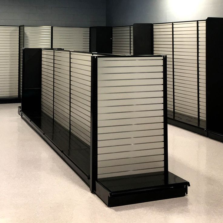 an empty room with several metal partitions on the floor and one is closed up