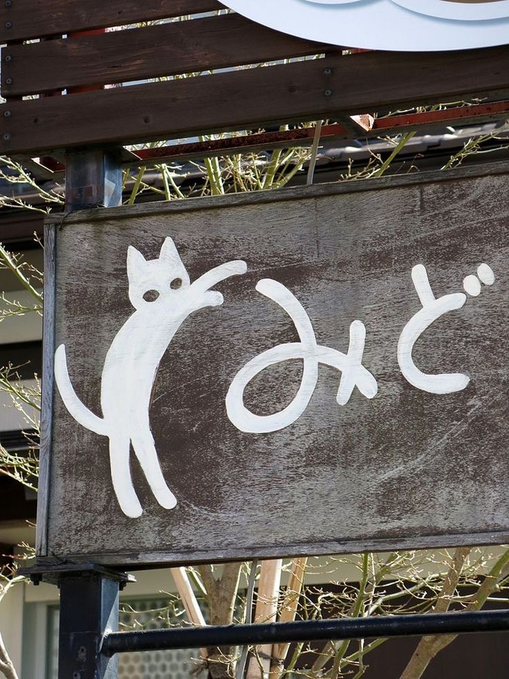 a sign that is on the side of a building with a cat painted on it