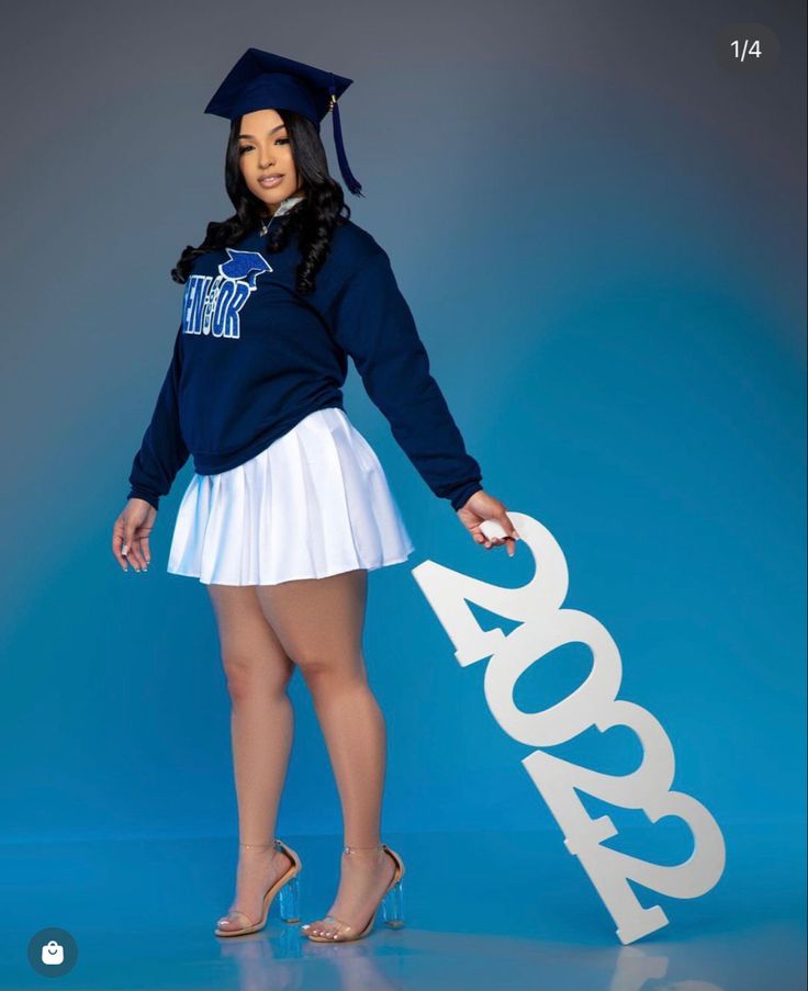 a woman in a graduation cap and skirt holding a sign