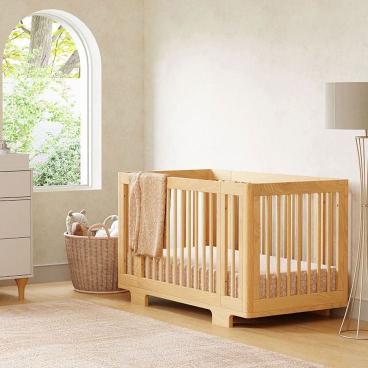 a baby's room with a crib, dresser and lamp in the corner