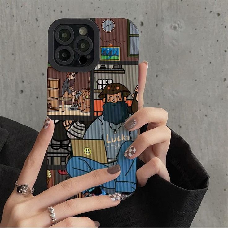 a woman holding up her phone case with cartoon pictures on it