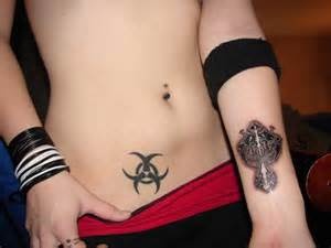 two people with tattoos on their stomachs, one has a cross and the other has a skull