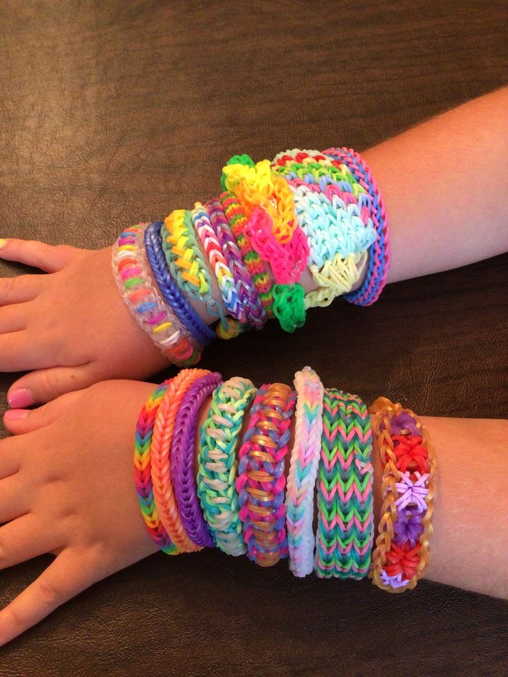 two children's hands with colorful bracelets on them