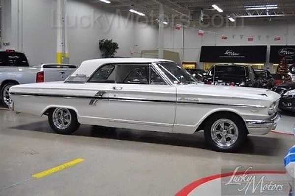 an old white car parked in a garage