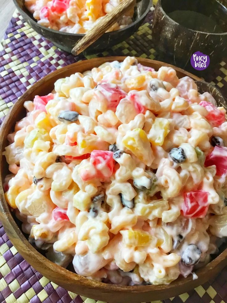 a bowl filled with macaroni salad on top of a purple and yellow table cloth