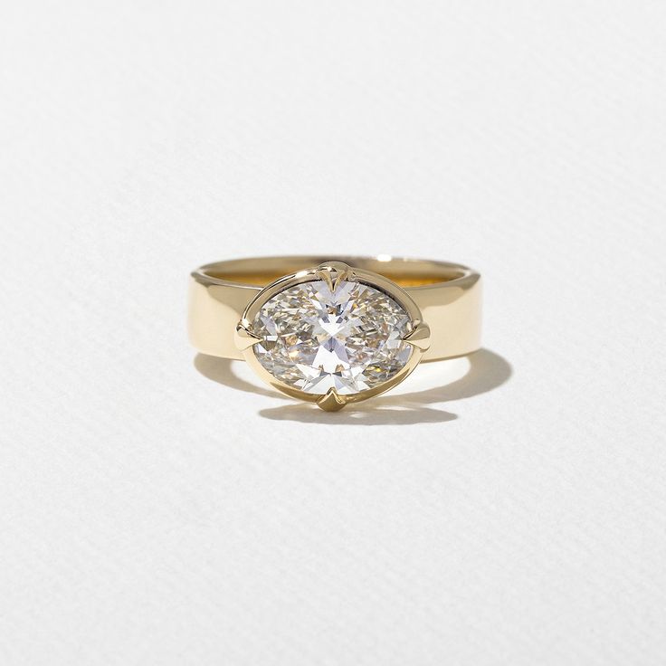 a yellow gold ring with a diamond in the center