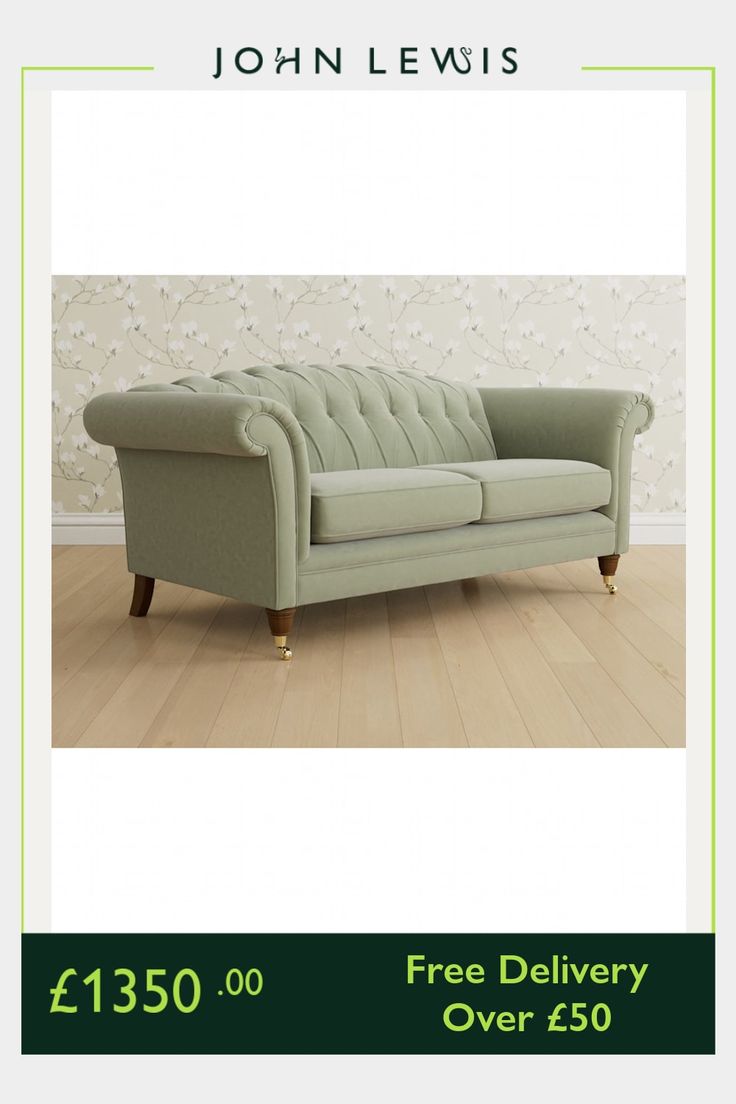 a green couch sitting on top of a wooden floor