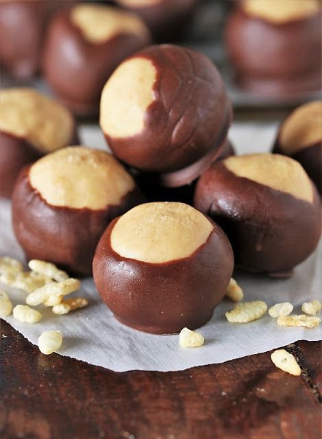 chocolate covered peanut butter balls sitting on top of a wooden table