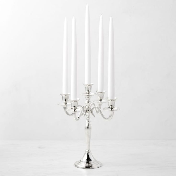 a silver candelabra with five white candles