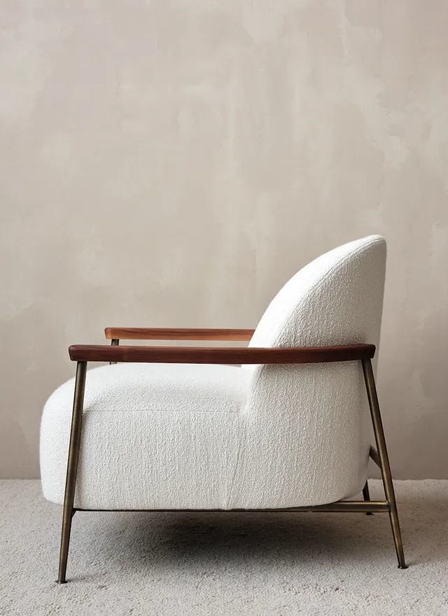 a white chair sitting on top of a carpeted floor next to a beige wall