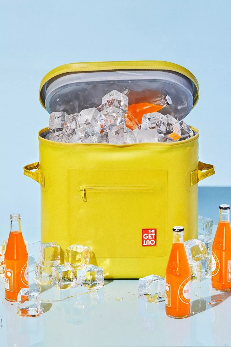 an ice bucket filled with orange sodas and bottles