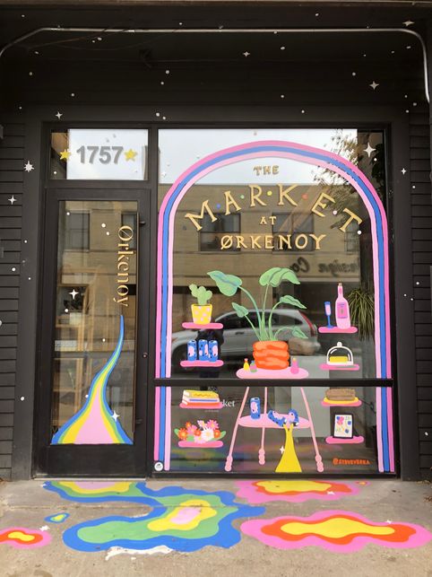 a storefront with an artful display in the window and painted floors on both sides