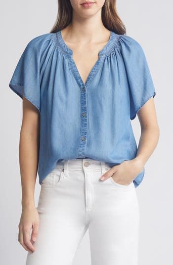 Soft gathers lend graceful movement to this soft chambray shirt framed by fluttering sleeves. 25 1/2" length Front button closure Split neck Short sleeves 100% lyocell Machine wash, tumble dry Imported Casual Medium Wash Blouse, Chic Short Sleeve Relaxed Fit Denim Top, Chic Relaxed Fit Short Sleeve Denim Top, Casual Light Wash Tencel Tops, Relaxed Fit Denim Tops For Daywear, Chic Short Sleeve Top In Medium Wash, Casual Flutter Sleeve Blouse For Fall, Spring Medium Wash Tencel Denim Top, Spring Light Wash Tencel Denim Top