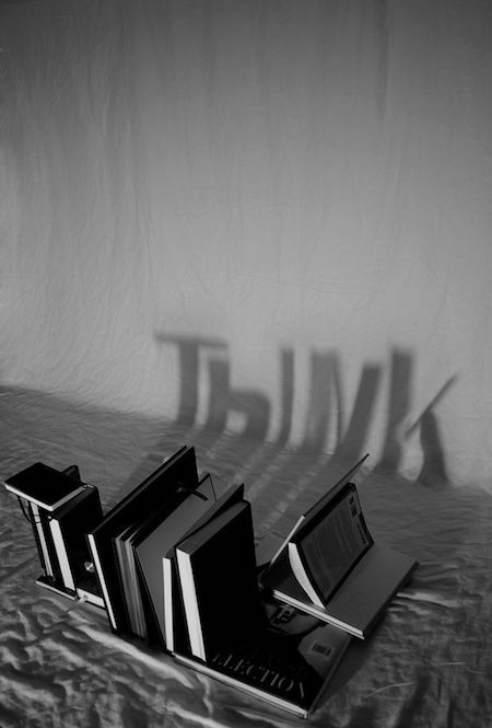 three books are laying on a bed with the word think spelled in front of them